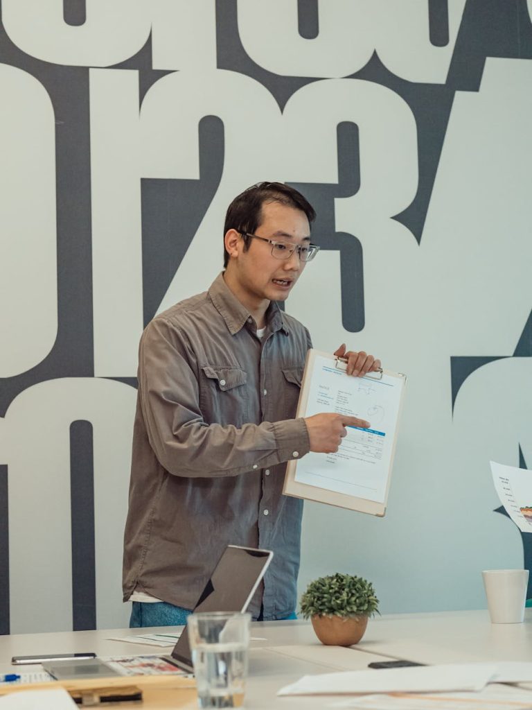 man with clipboard speaking at an event