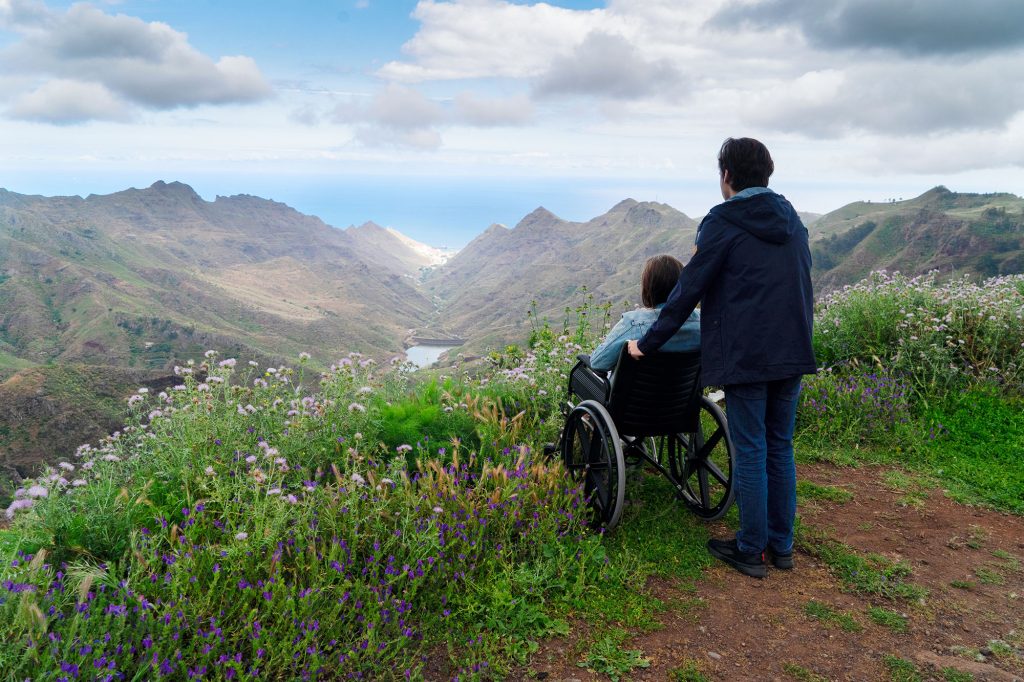 young man and his wife in a wheelchair looking over a cliff