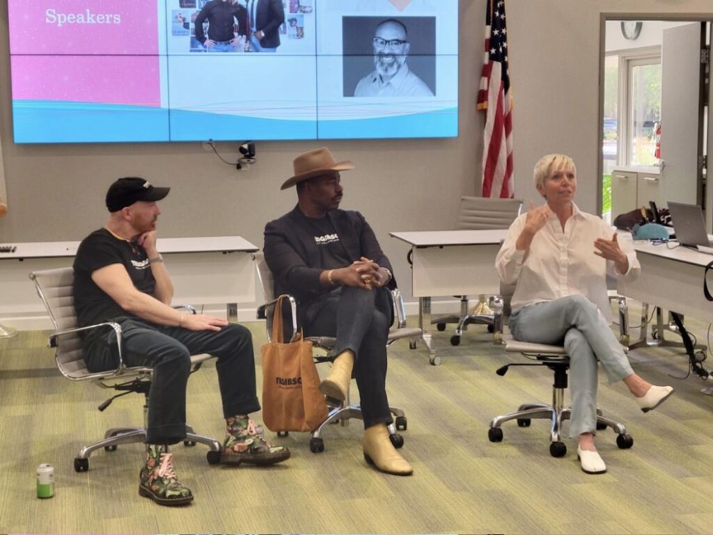 Three speakers seated in front of a Speakers screen during a session at the LGBTQ+ Student Summit in Palm Springs, October 2025.